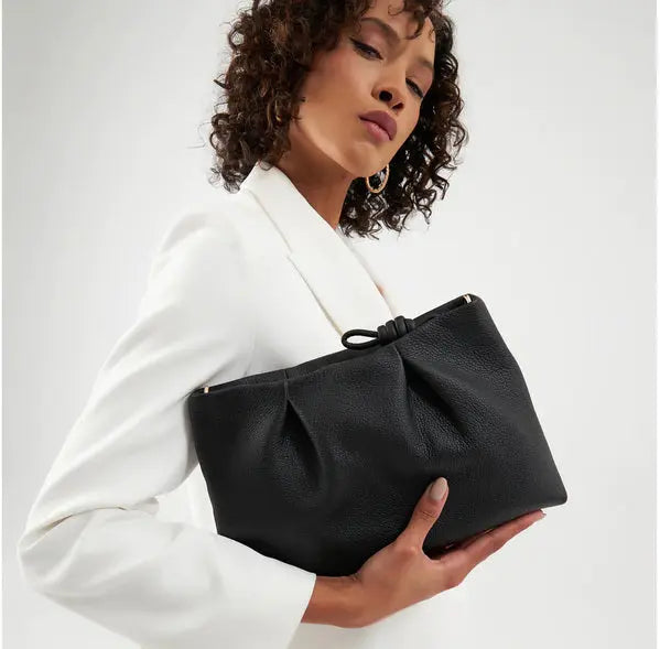 young women carry black crossbody bag in park